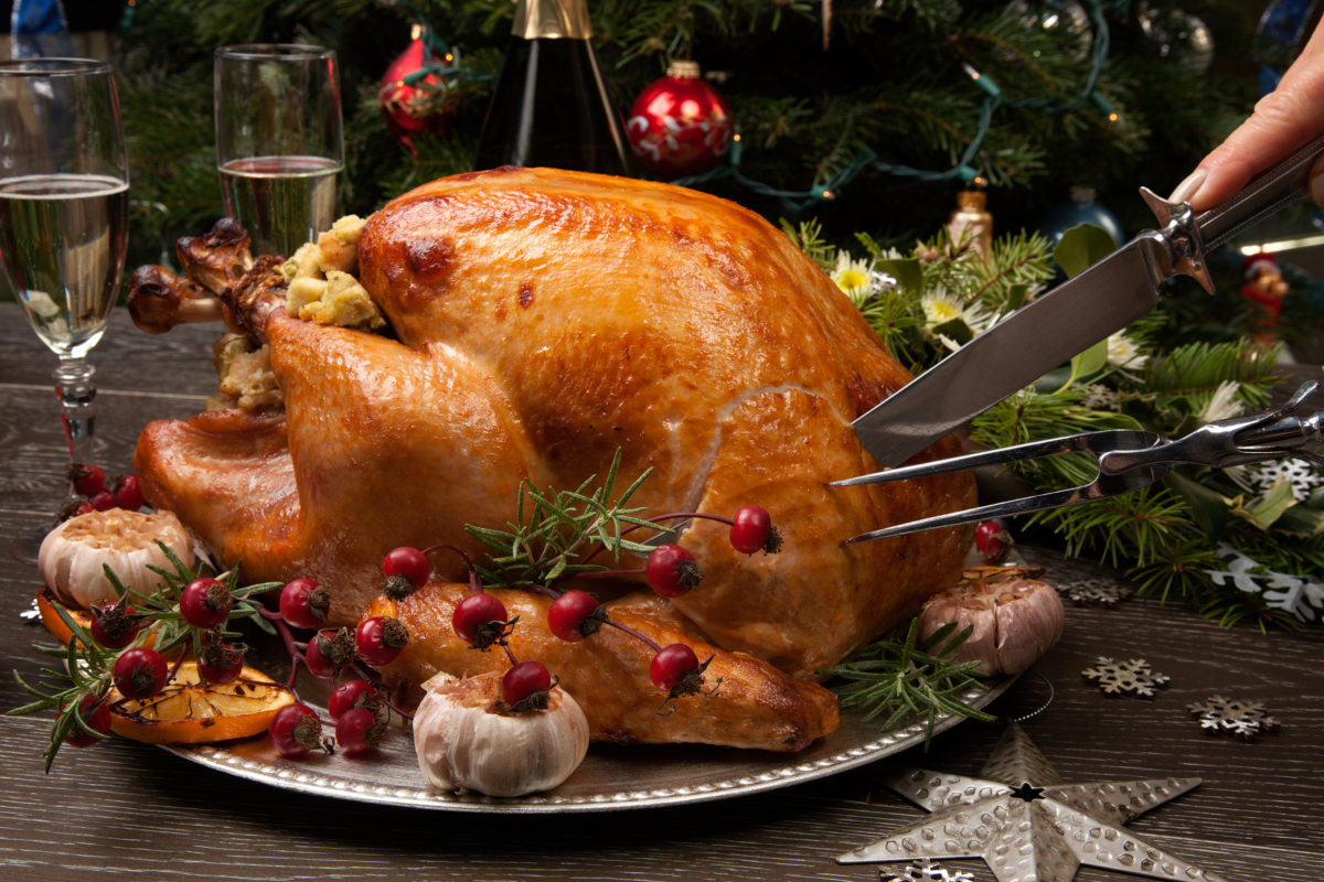 Christmas turkey being cut with 2 glasses of champagne