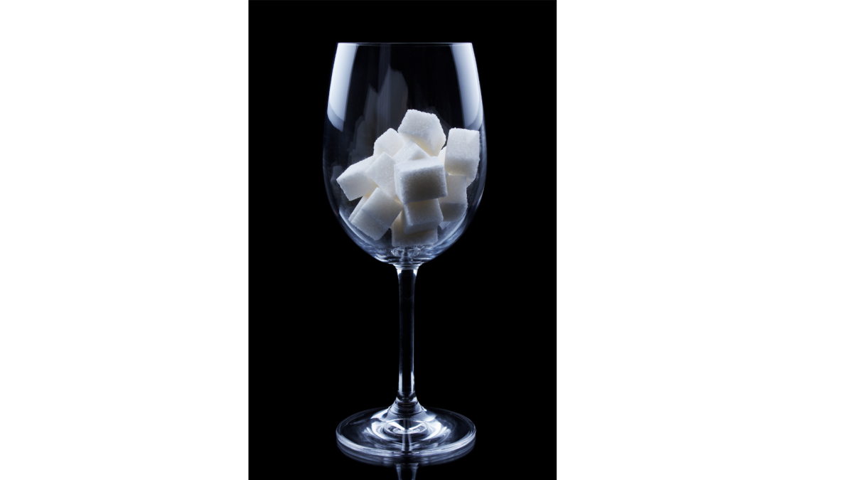 Empty Wine glass with sugar cubes in, against black background
